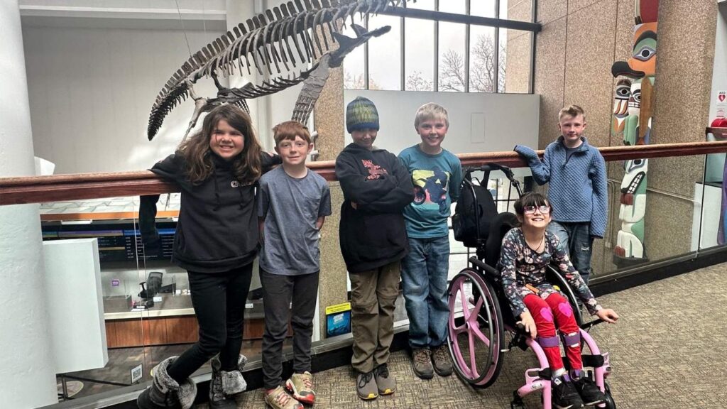 group of kids smiling on field trips at local science museum