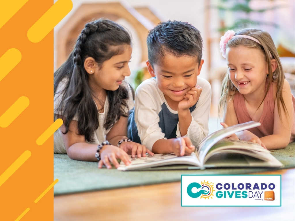 three kids smiling and reading a book