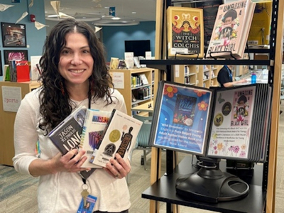 Soshannah holding books in library