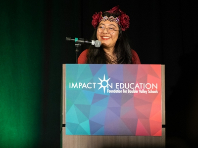 Cecilia smiling and speaking at a podium