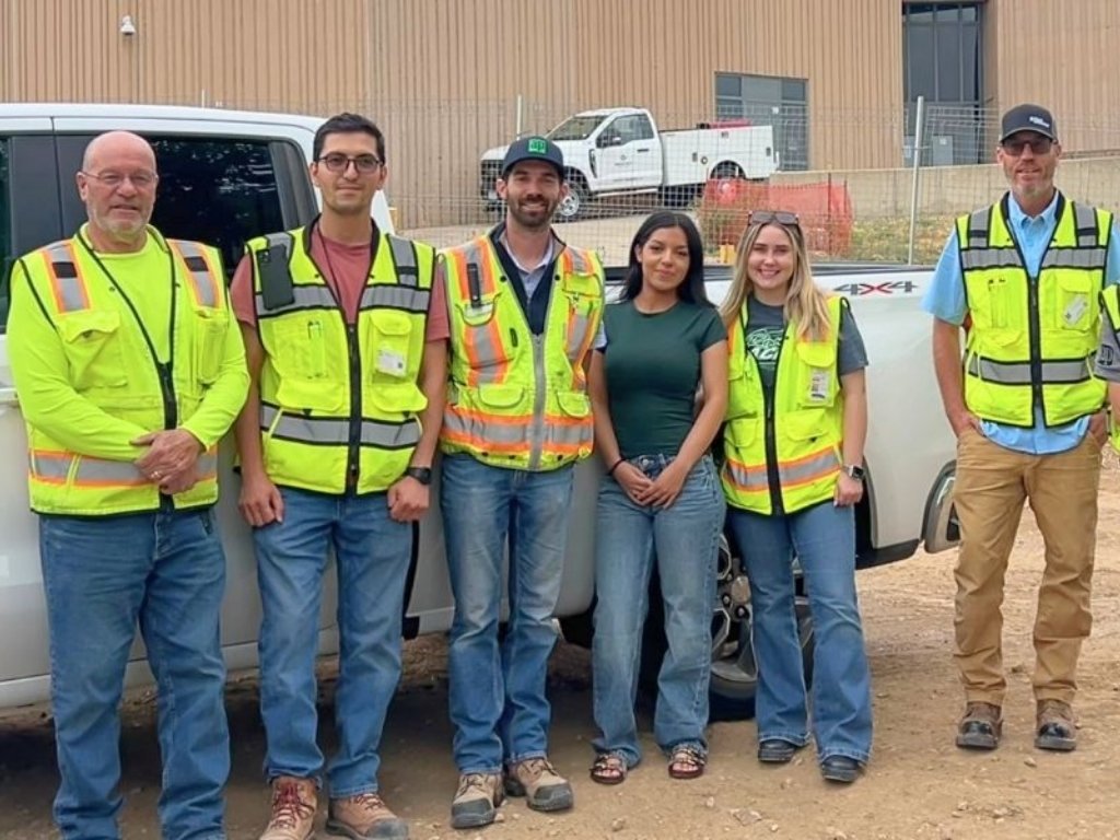 Stacy and construction colleagues in safety vests